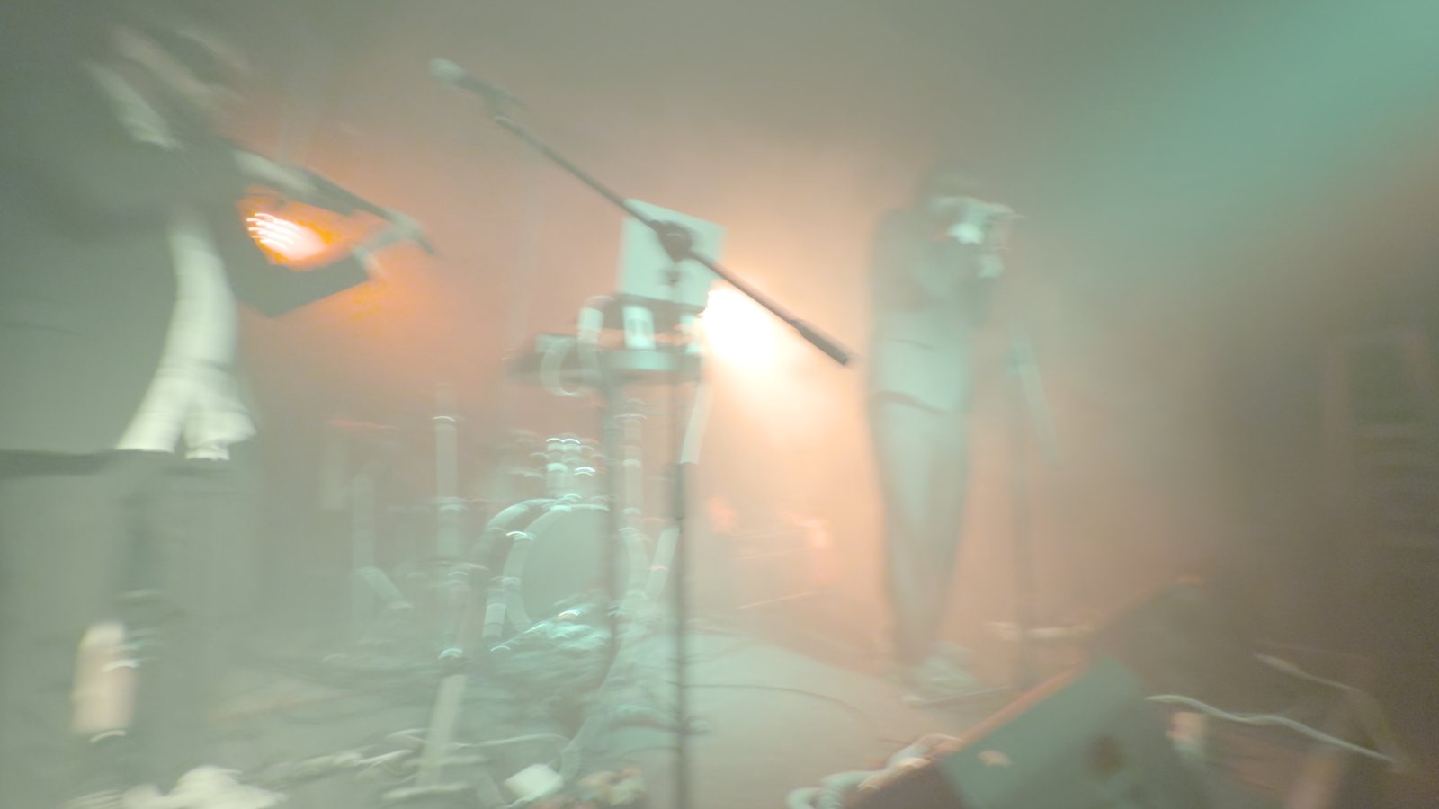 The stage in green-tinted haze with a single lamp