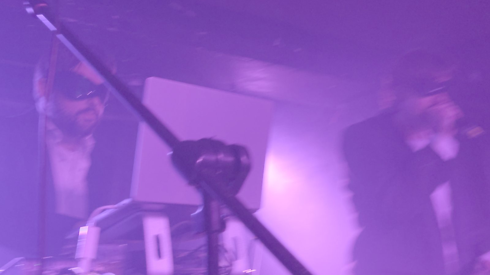 Wide shot of the band through violet haze