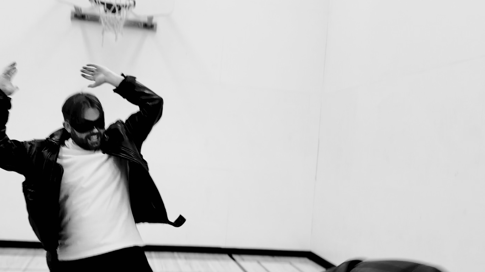 Black-and-white still of one figure grabbing another
