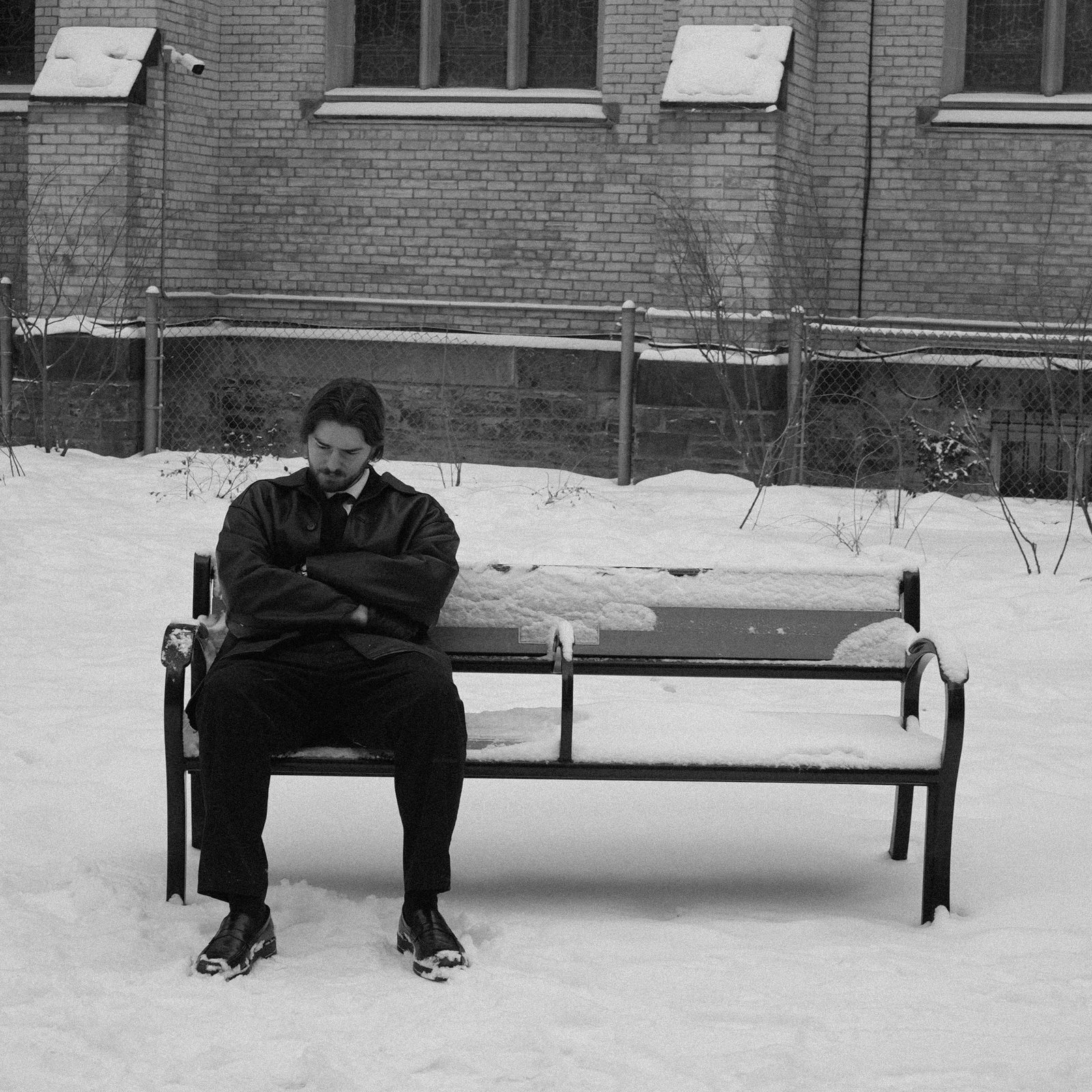 Quinn Mills seated alone on a bench in the snow