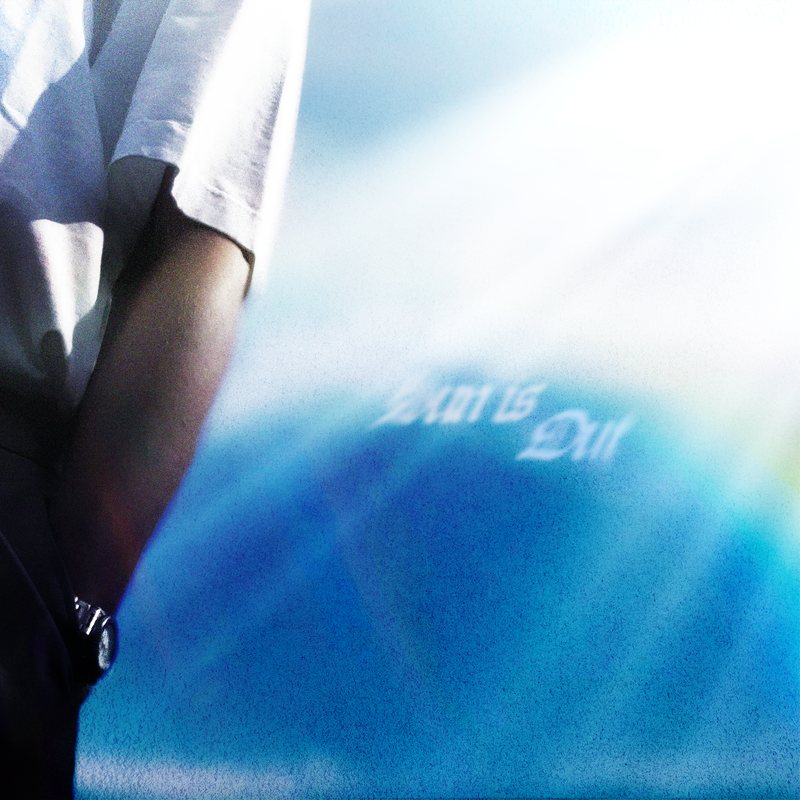 Arm and white sleeve against a bright sky, glassy blue title, lens flare